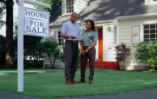 Stock photo of couple in front of house for sale